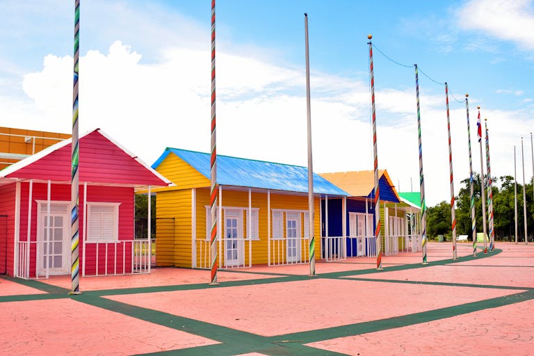 Brightly painted houses with flag poles under clear skies. Ideal for architecture and travel themes.