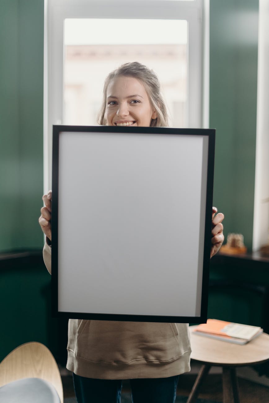 woman holding black frame with white screen
